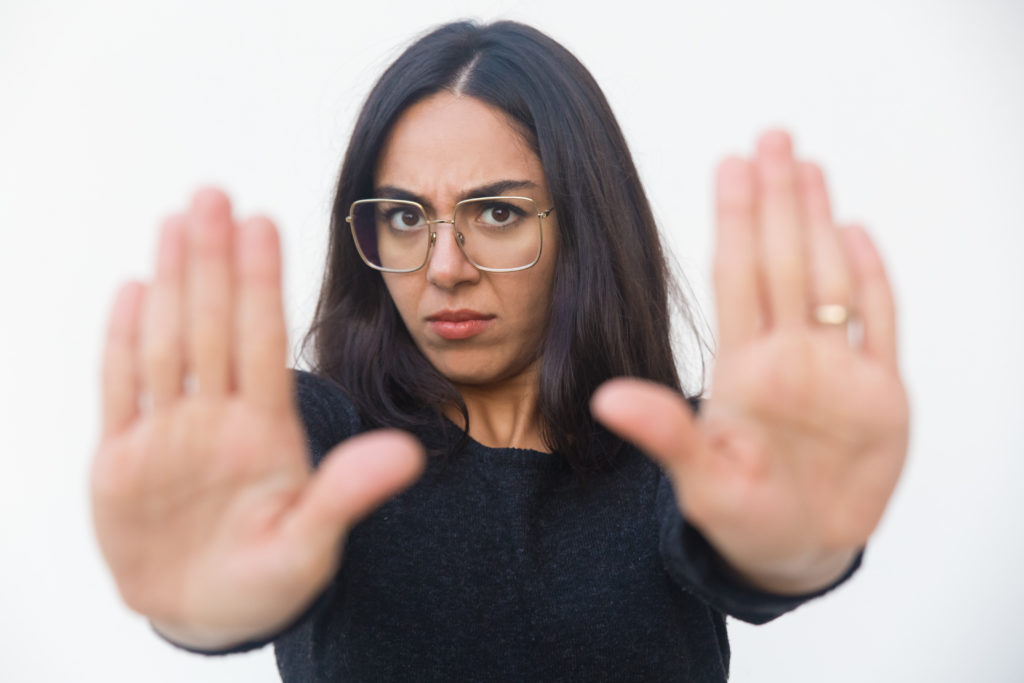 Woman with glasses holding up hands